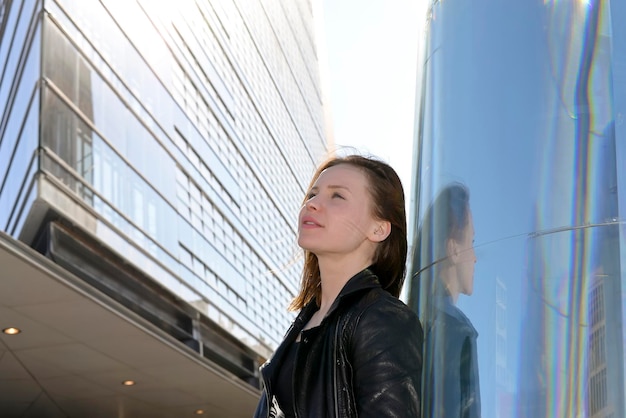 Zdjęcie piękna młoda kobieta patrząca w stronę budynków w mieście