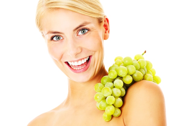 piękna młoda kobieta pozuje z winogronami na białym tle