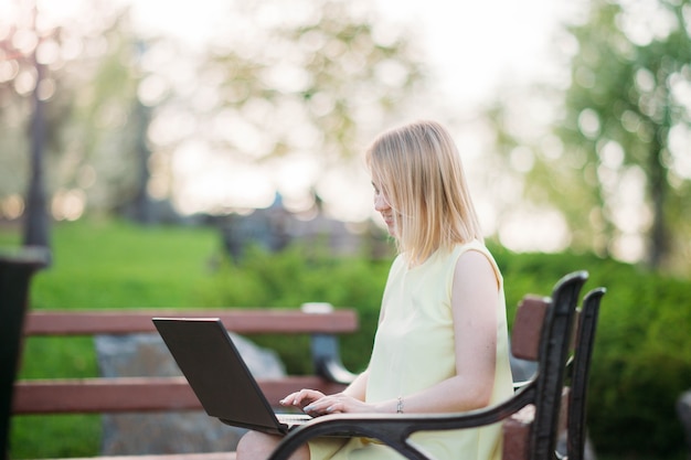 piękna młoda kobieta pracuje na laptopie w parku dziewczyna freelancer w przyrodzie