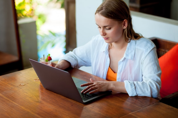 Piękna młoda kobieta pracuje na swoim laptopie