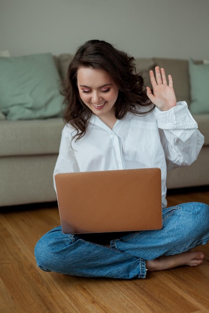 Zdjęcie piękna młoda kobieta pracuje online w domu z laptopem home office studiuj online media społecznościowe rozmowa wideo przytulny dom