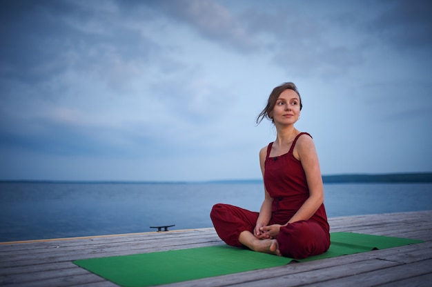 Piękna młoda kobieta praktykuje jogę asana Padmasana