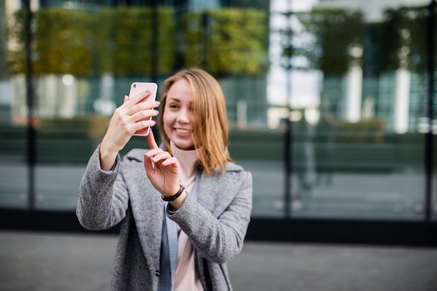 Piękna młoda kobieta robi selfie zdjęcie z smartphone.