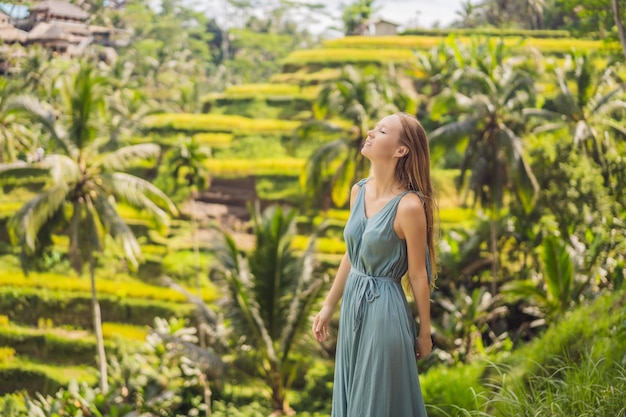 Piękna młoda kobieta spacer po typowym azjatyckim wzgórzu z uprawą ryżu w kształcie góry zielony kaskadowy pole ryżowe tarasy ryżowe Ubud Bali Indonezja Bali koncepcja podróży
