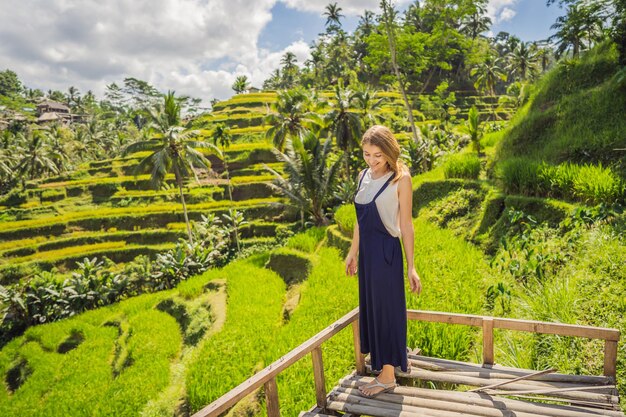 Piękna młoda kobieta spacer po typowym azjatyckim wzgórzu z uprawą ryżu w kształcie góry zielony kaskadowy pole ryżowe tarasy ryżowe Ubud Bali Indonezja Bali koncepcja podróży