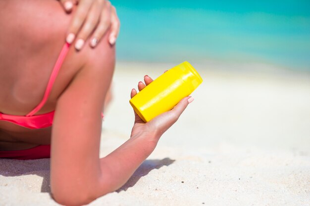 Piękna Młoda Kobieta Trzyma Suncream Kłama Na Tropikalnej Plaży