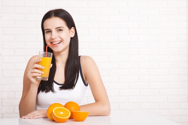 piękna młoda kobieta trzymając w ręku szklankę z sokiem pomarańczowym i uśmiechnięty