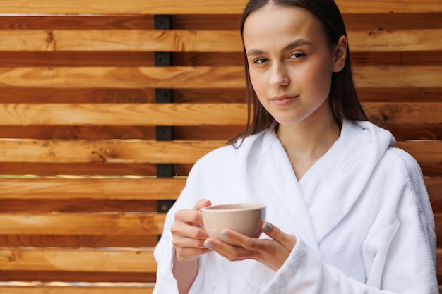 Piękna młoda kobieta w bathrobe ma herbaty