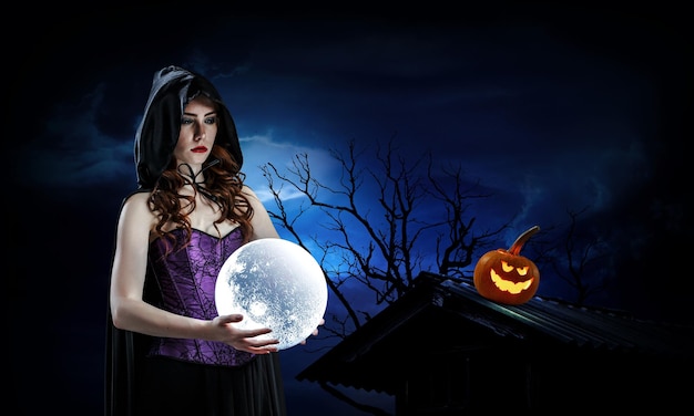Zdjęcie piękna młoda kobieta w czarownice kapelusz i kostium. projekt sztuki halloween. różne środki przekazu