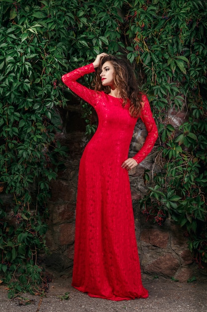 Piękna młoda kobieta w długiej czerwonej sukni