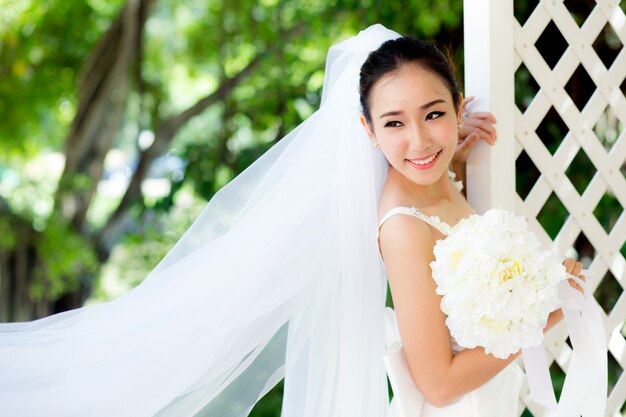 Zdjęcie piękna młoda kobieta w dniu ślubu w białej sukni w ogrodzie