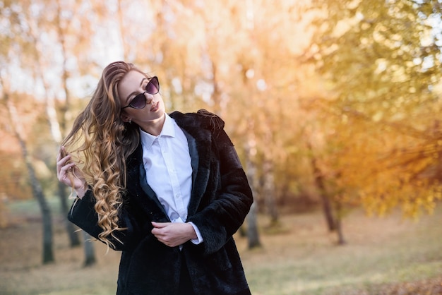 Piękna młoda kobieta w futrze w magicznym lesie jesienią.