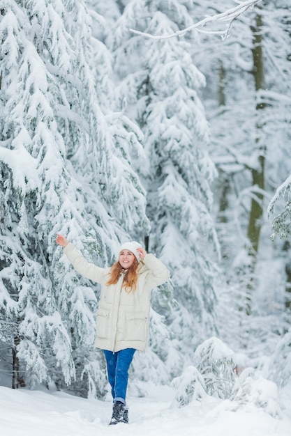 Piękna młoda kobieta w śnieżnym lesie. Świerkowe gałęzie na śniegu. Piękna zima. Zimowy las.