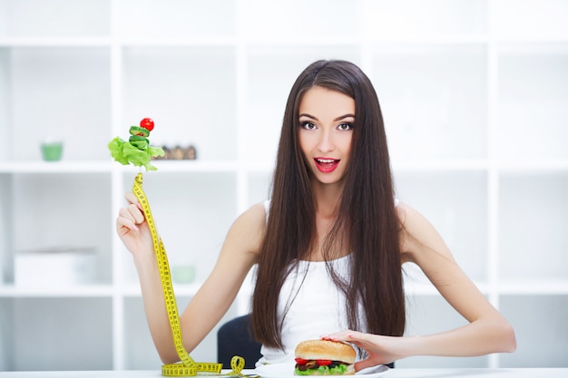 Piękna Młoda Kobieta Wybiera Między Zdrowym Jedzeniem I Fast Foodami