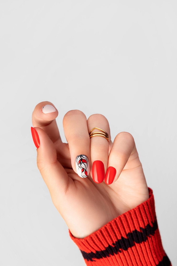 Zdjęcie piękna młoda kobieta z czerwonym manicure na szarym tle