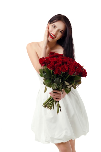 Piękna młoda kobieta z wielkim bukietem czerwonych róż