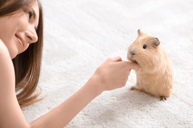 Piękna młoda kobieta ze świnką morską w domu