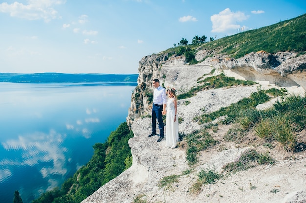 piękna młoda para pozowanie na skale w pobliżu jeziora