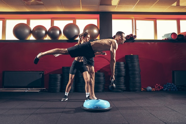 Piękna Młoda Para Sportowy Trening W Siłowni Razem. Kaukaski Mężczyzna Szkolenia Z Kobieta Trener. Pojęcie Sportu, Aktywności, Zdrowego Stylu życia, Siły I Mocy. Trening Z Ciężarami.