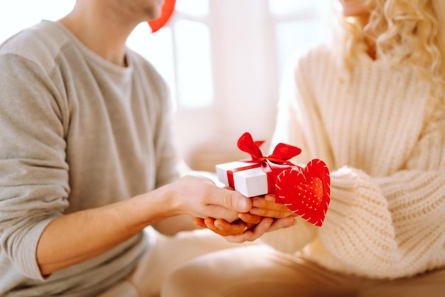 Piękna młoda para świętuje Walentynki w domu Kochankowie dają sobie nawzajem prezenty