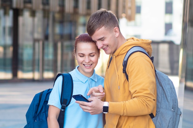 Piękna Młoda Para, Szczęśliwi Studenci Z Plecakami Stojący Razem Na Zewnątrz W Kampusie.