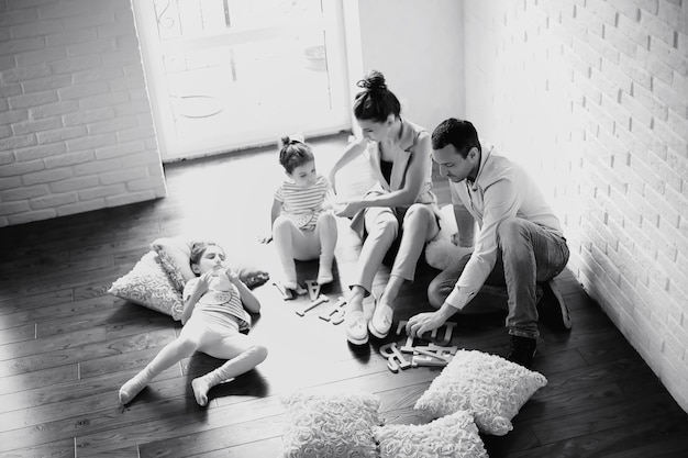 Piękna młoda rodzina z córkami na sesji zdjęciowej w białym studio