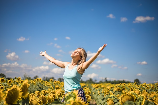 Piękna nasłoneczniona kobieta na żółtym polu słonecznika Pojęcie wolności i szczęścia. Szczęśliwa dziewczyna na zewnątrz