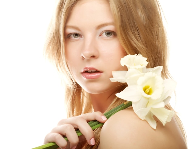 Piękna nastolatka uśmiechnięta iz kwiatem Narcyzem i patrząc na kamery.