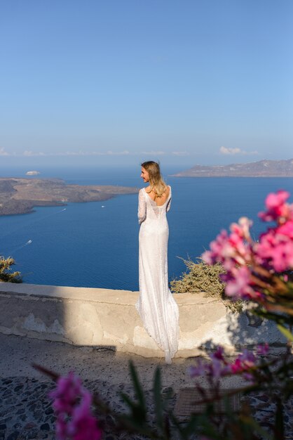 Piękna Panna Młoda W Białej Sukni Pozuje Na Tle Morza śródziemnego W Thira, Santorini.