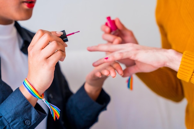 Piękna para gejów nakładająca makijaż malując paznokcie jest romantyczna w domu koncepcja lgbt