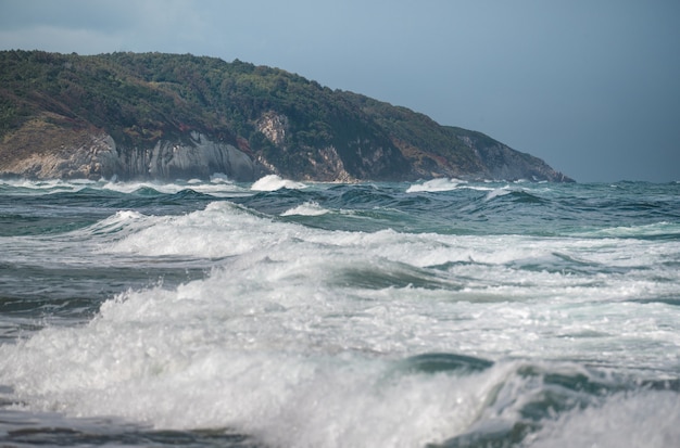 Piękna piaszczysta plaża oceaniczna z dużymi skałami na brzegu iw wodzie. Potężne fale na oceanie. Plusk wody oceanu na skalnej plaży z chropowatymi klifami. Plaża Agva Turcja