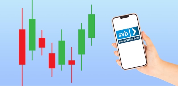 Piękna ręka z telefonem komórkowym z logo SVB Silicon Valley Bank na oryginalnym ekranie z grafiką