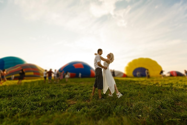 Piękna romantyczna para przytulanie na łące. balon na ogrzane powietrze na tle