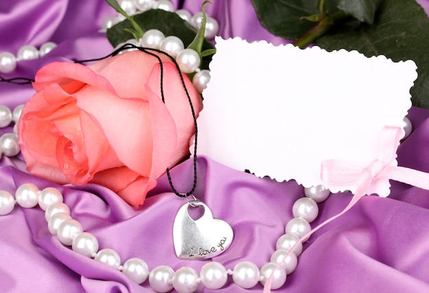 Zdjęcie piękna różowa róża z zawieszką w kształcie serca