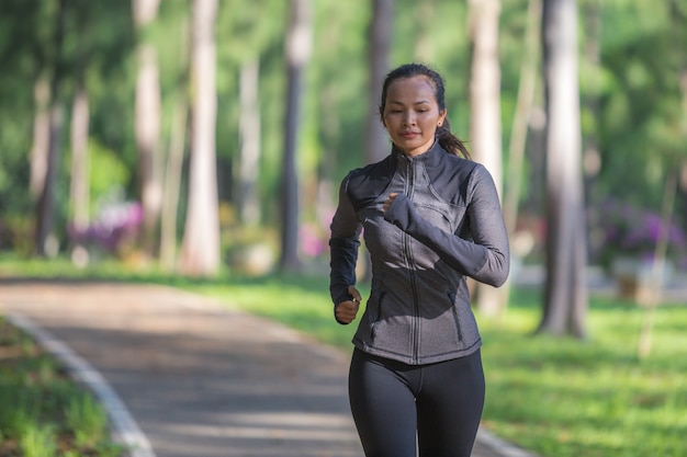 Zdjęcie piękna sport kobieta w sportswear bieg w parku. pojęcie zdrowego stylu życia i sportu.