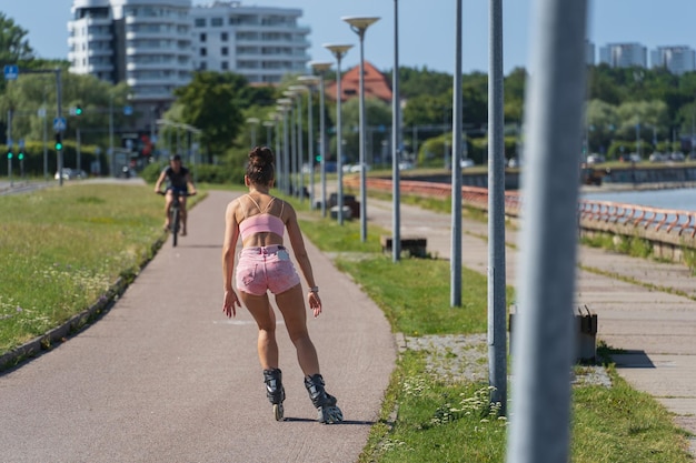 Piękna sportsmenka jeździ na rolkach na promenadzie w Tallinie w letni dzień