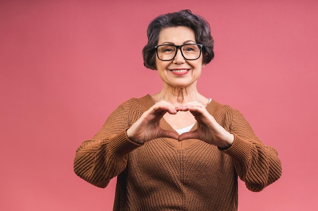 Zdjęcie piękna stara babcia patrząca w kamerę i uśmiechająca się