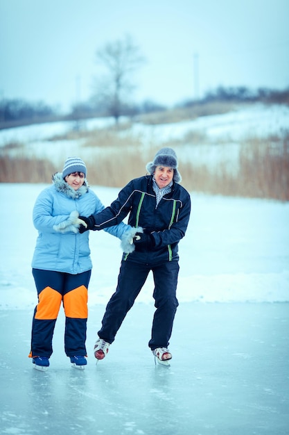 Piękna starsza kobieta i mężczyzna w słonecznej zimie natura na łyżwach.