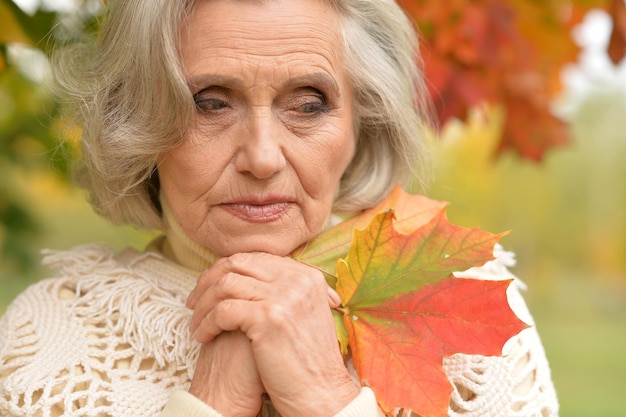 Piękna starsza kobieta pozuje na zewnątrz jesienią
