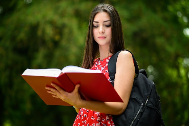 Piękna studentka czytająca książkę na świeżym powietrzu