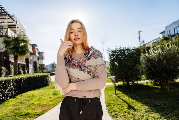 Piękna stylowa blondynka spacery na świeżym powietrzu, w promieniach wiosennego słońca, pozowanie