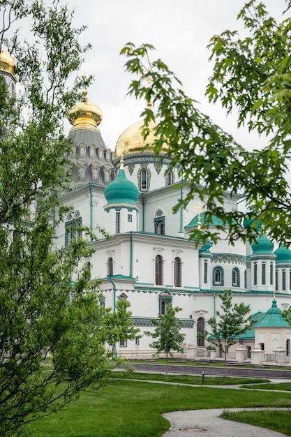 Piękna świątynia prawosławna Nowa Jerozolima w Rosji w liściach drzew Religia i wiara Vertical