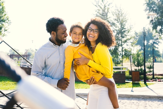 Piękna, szczęśliwa afroamerykańska rodzinna więź w parku - Czarna rodzina bawi się na świeżym powietrzu