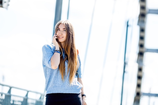 Piękna szczęśliwa młoda bizneswoman za pomocą telefonu komórkowego na ulicy miasta