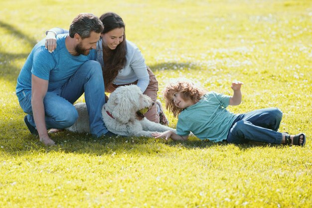 Zdjęcie piękna szczęśliwa rodzina bawi się z psem na zewnątrz śliczny portret rodzinny koncepcja szczęśliwego f