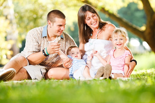 Piękna szczęśliwa rodzina bawiąca się w parku?