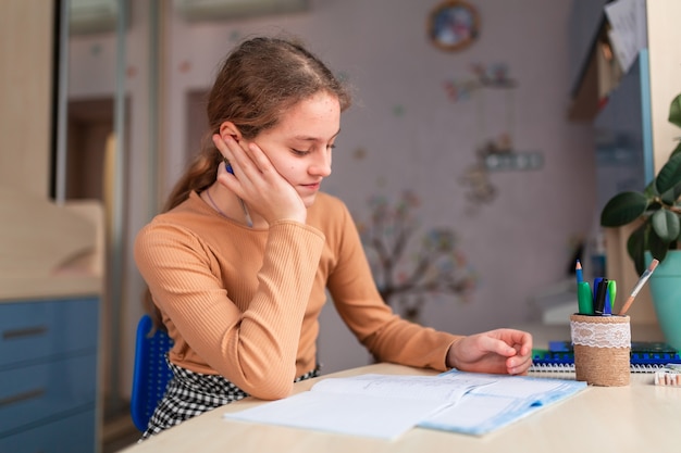 Piękna Uczennica Studiuje W Domu Odrabiania Lekcji W Szkole. Książki Szkoleniowe I Notatnik Na Stole. Edukacja Online Na Odległość