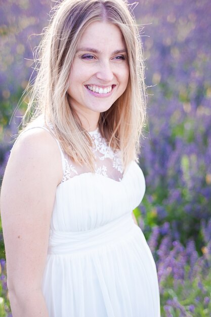 Zdjęcie piękna uśmiechnięta kobieta w ciąży na boisku