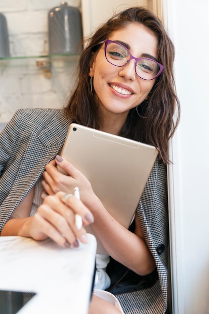 Piękna uśmiechnięta młoda kobieta z laptopem w kawiarni. Biznes online, szkolenia i biznes.