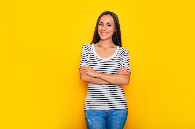 Piękna, Uśmiechnięta, Nowoczesna Brunetka W Stroju Casual Pozuje Przed żółtą ścianą